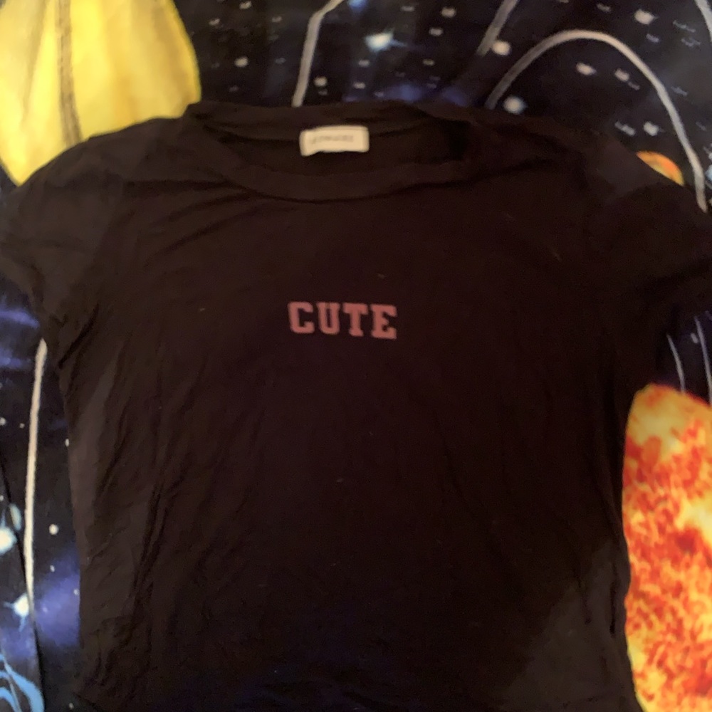 black t shirt with word “cute” across the upper area